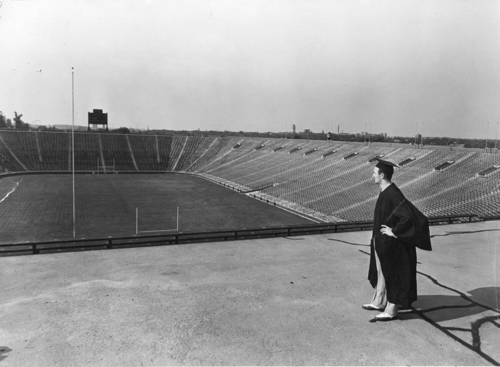 Tom Harmon stands looking out at Michigan Stadium