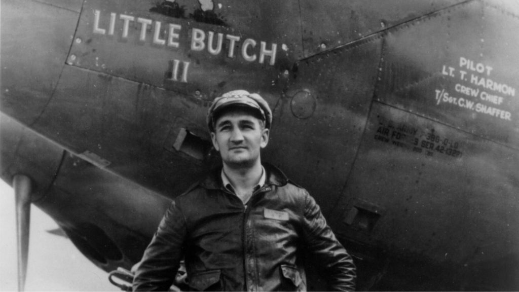 Tom Harmon stands before his plane